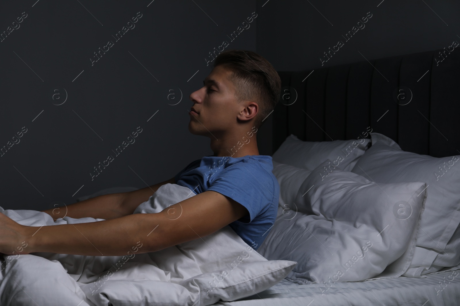 Photo of Young man suffering from sleepwalking on bed at home