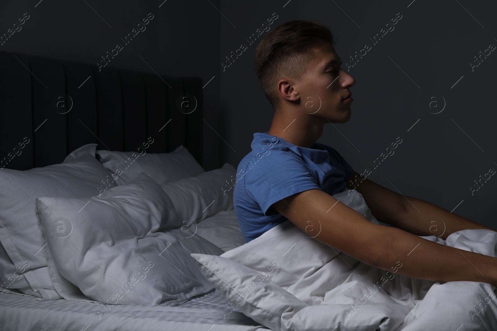 Photo of Young man suffering from sleepwalking on bed at home