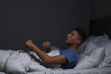 Photo of Young man suffering from sleepwalking on bed at home