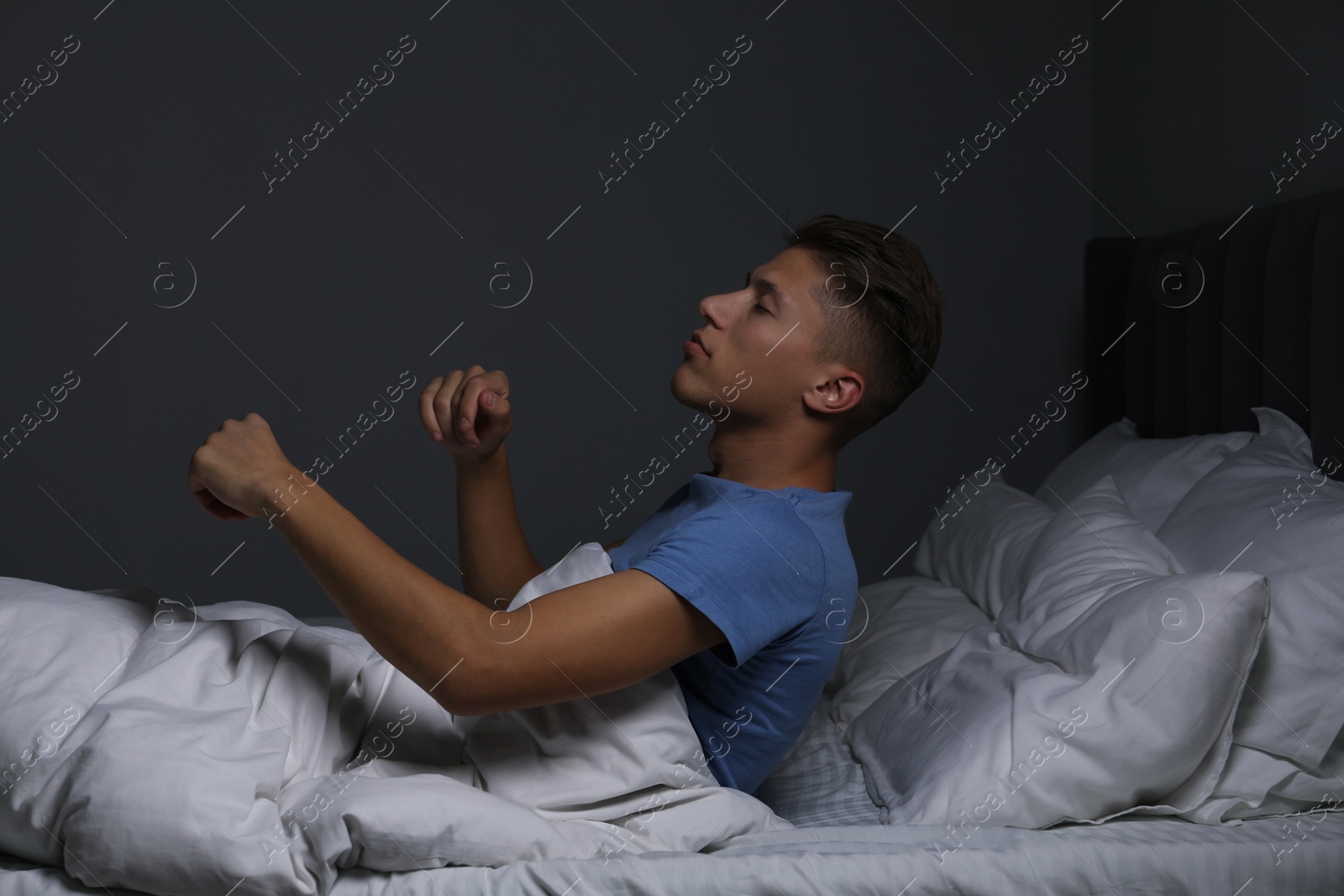 Photo of Young man suffering from sleepwalking on bed at home