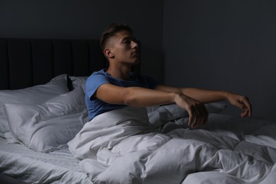 Photo of Young man suffering from sleepwalking on bed at home