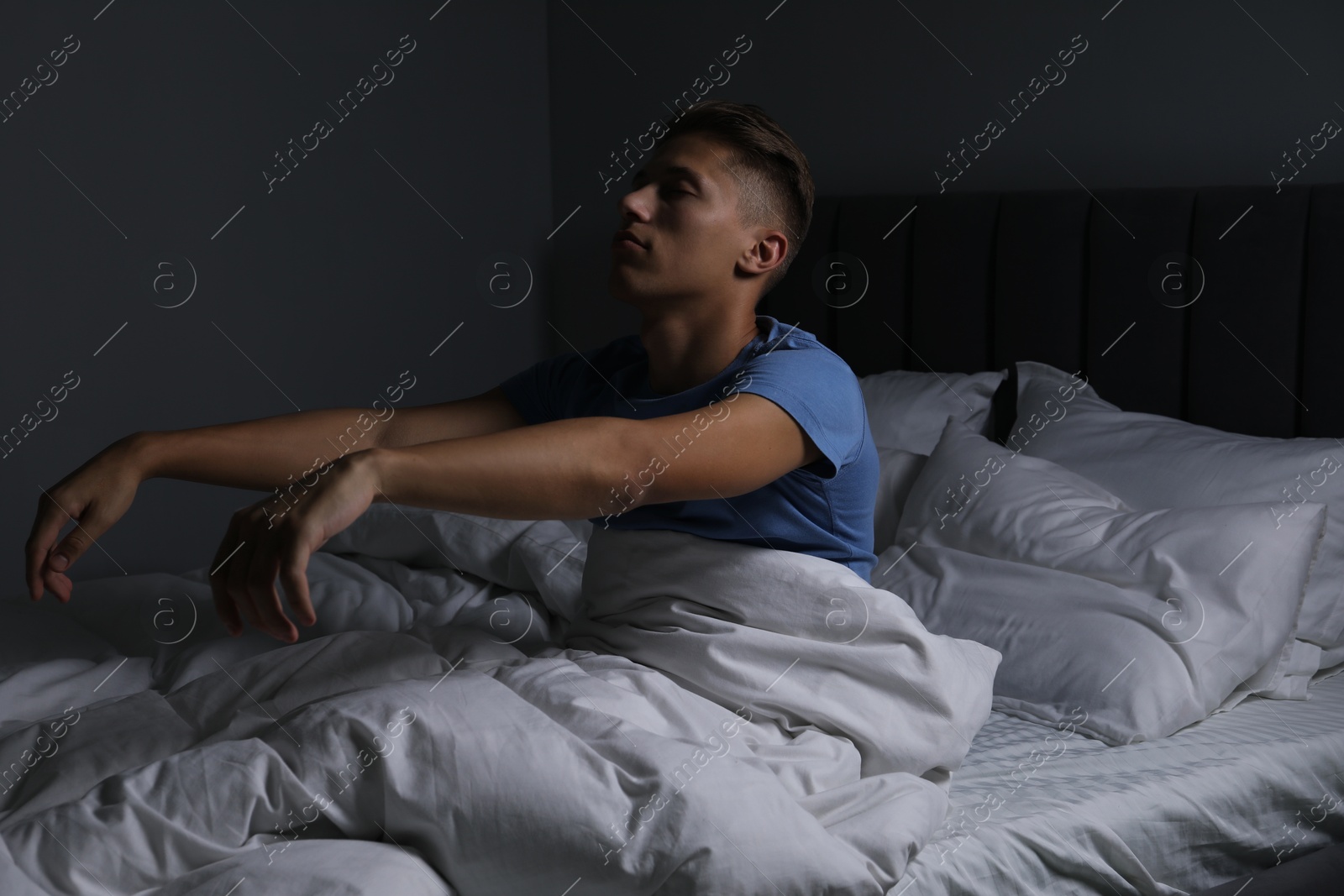 Photo of Young man suffering from sleepwalking on bed at home