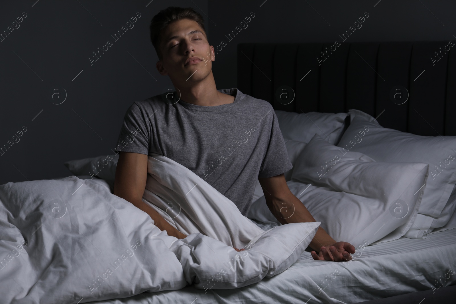 Photo of Young man suffering from sleepwalking on bed at home