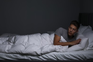 Photo of Young man suffering from sleepwalking on bed at home