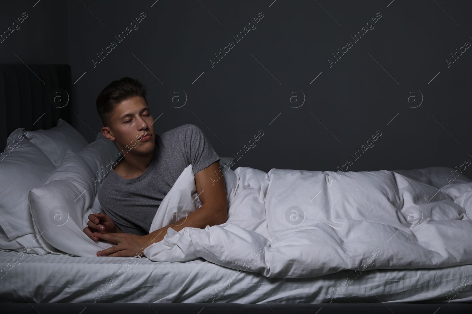 Photo of Young man suffering from sleepwalking on bed at home