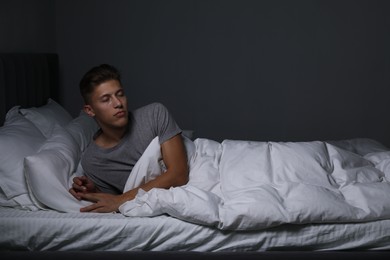 Photo of Young man suffering from sleepwalking on bed at home