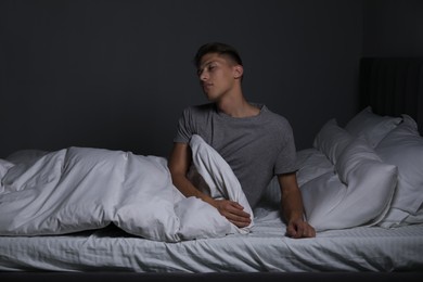 Young man suffering from sleepwalking on bed at home