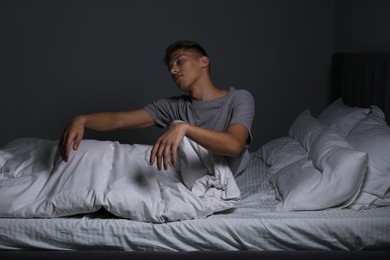 Photo of Young man suffering from sleepwalking on bed at home