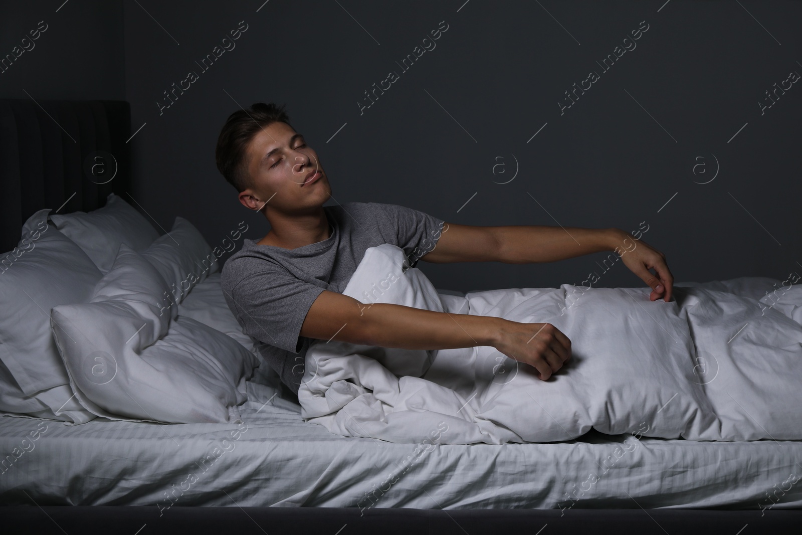 Photo of Young man suffering from sleepwalking on bed at home