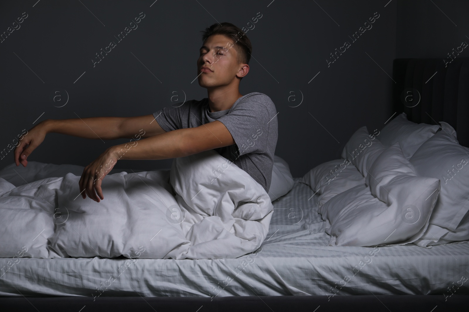 Photo of Young man suffering from sleepwalking on bed at home