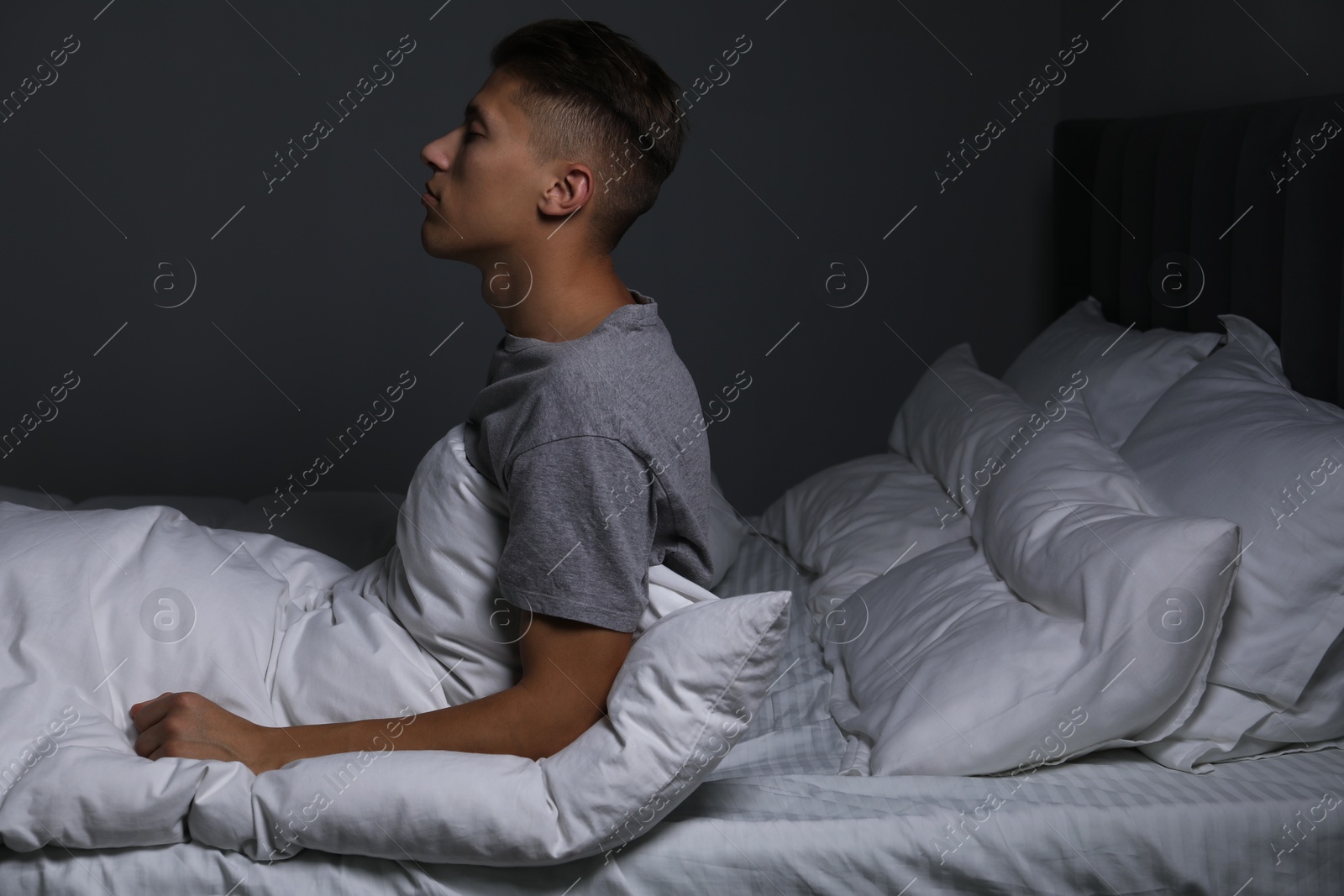 Photo of Young man suffering from sleepwalking on bed at home