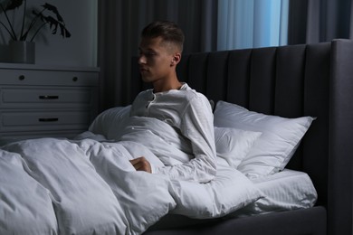 Photo of Young man suffering from sleepwalking on bed at home