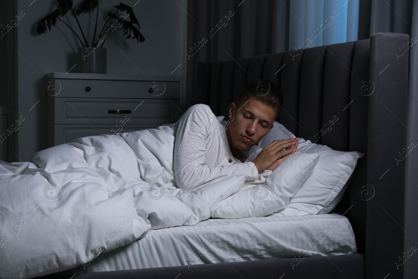 Photo of Young man suffering from sleepwalking on bed at home