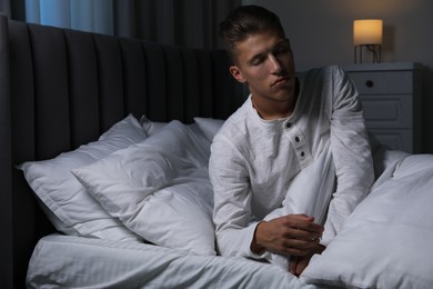 Photo of Young man suffering from sleepwalking on bed at home