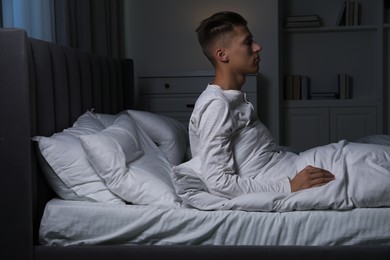 Photo of Young man suffering from sleepwalking on bed at home