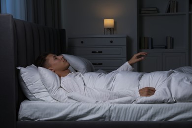 Photo of Young man suffering from sleepwalking on bed at home