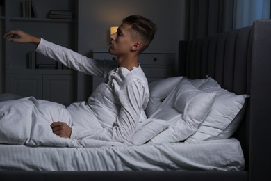 Photo of Young man suffering from sleepwalking on bed at home