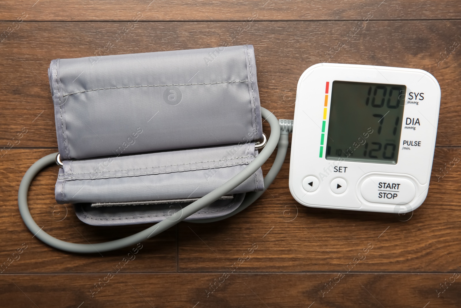 Photo of Blood pressure measuring device on wooden table, top view