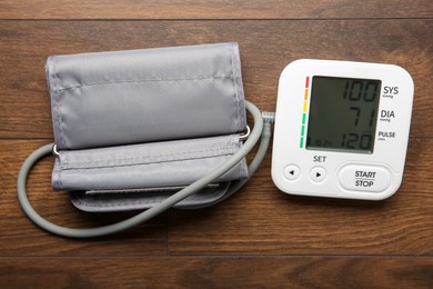 Photo of Blood pressure measuring device on wooden table, top view