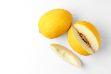 Photo of Fresh ripe melons on white table, top view. Space for text