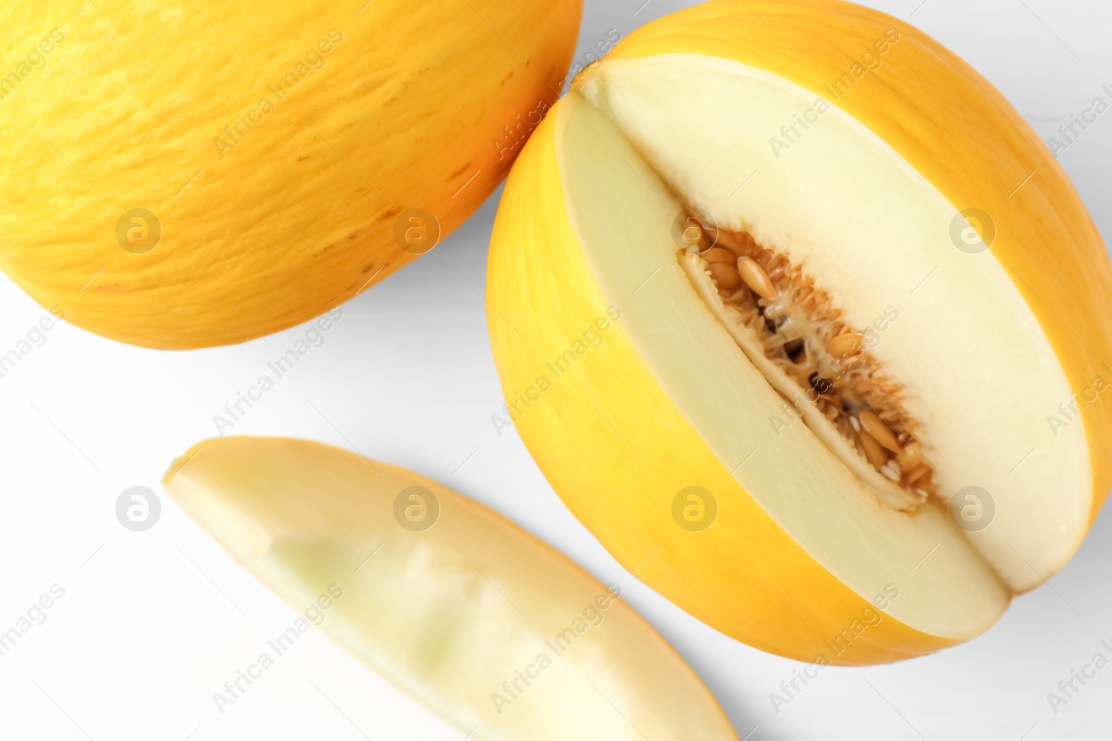 Photo of Fresh ripe melons on white table, top view