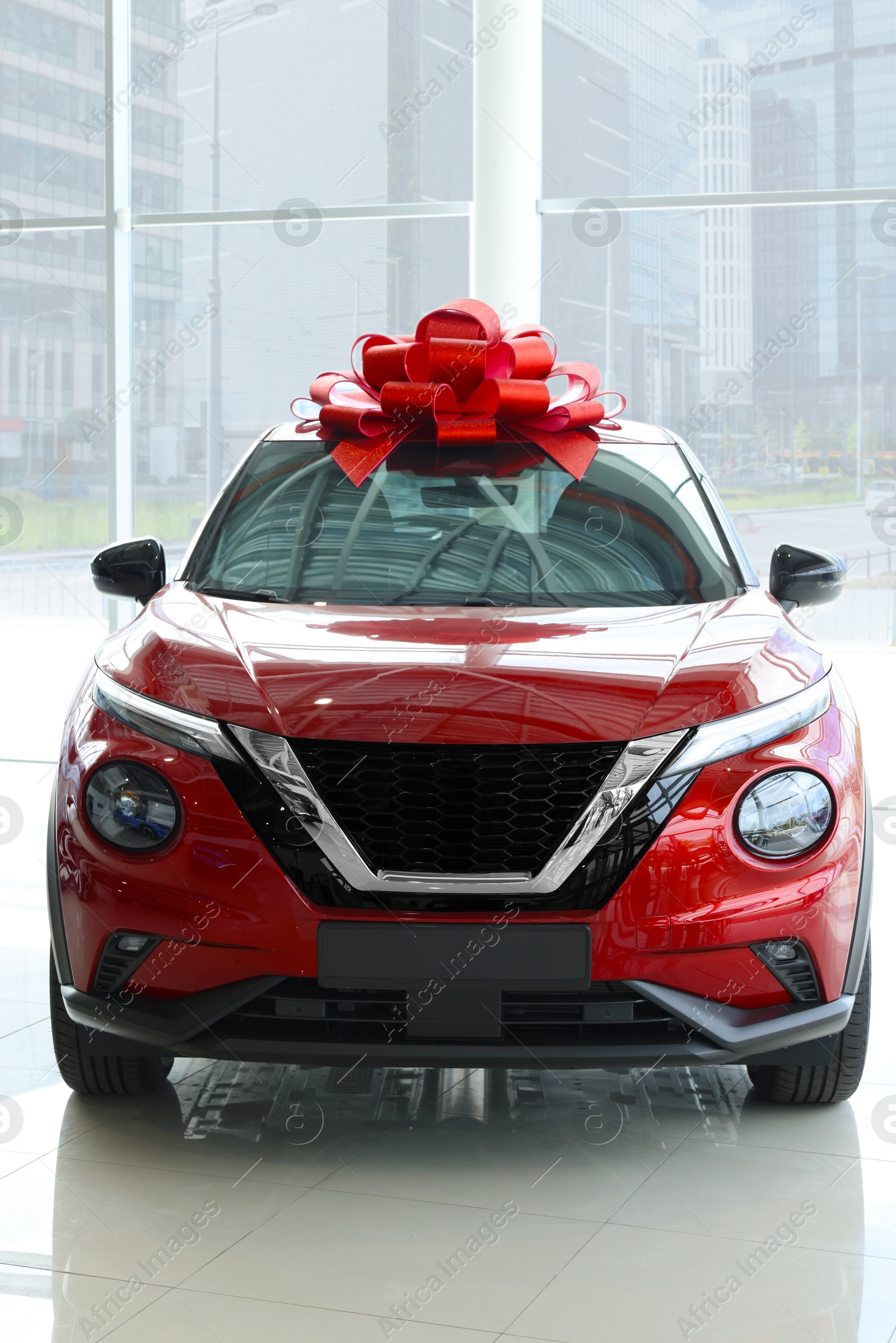 Photo of Luxury vehicle. New modern red car with bow in salon