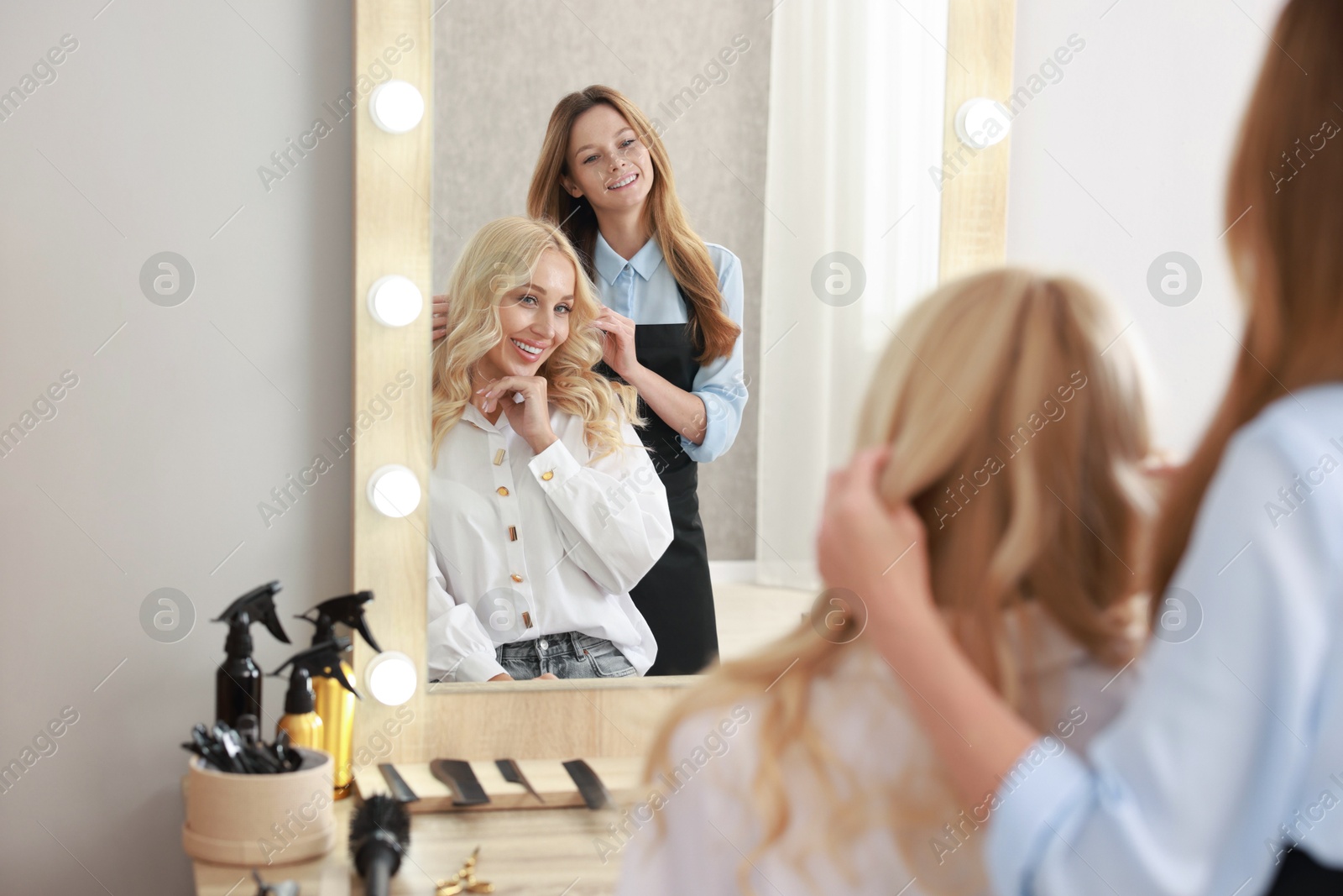 Photo of Hair cutting. Professional hairdresser working with client in salon, selective focus