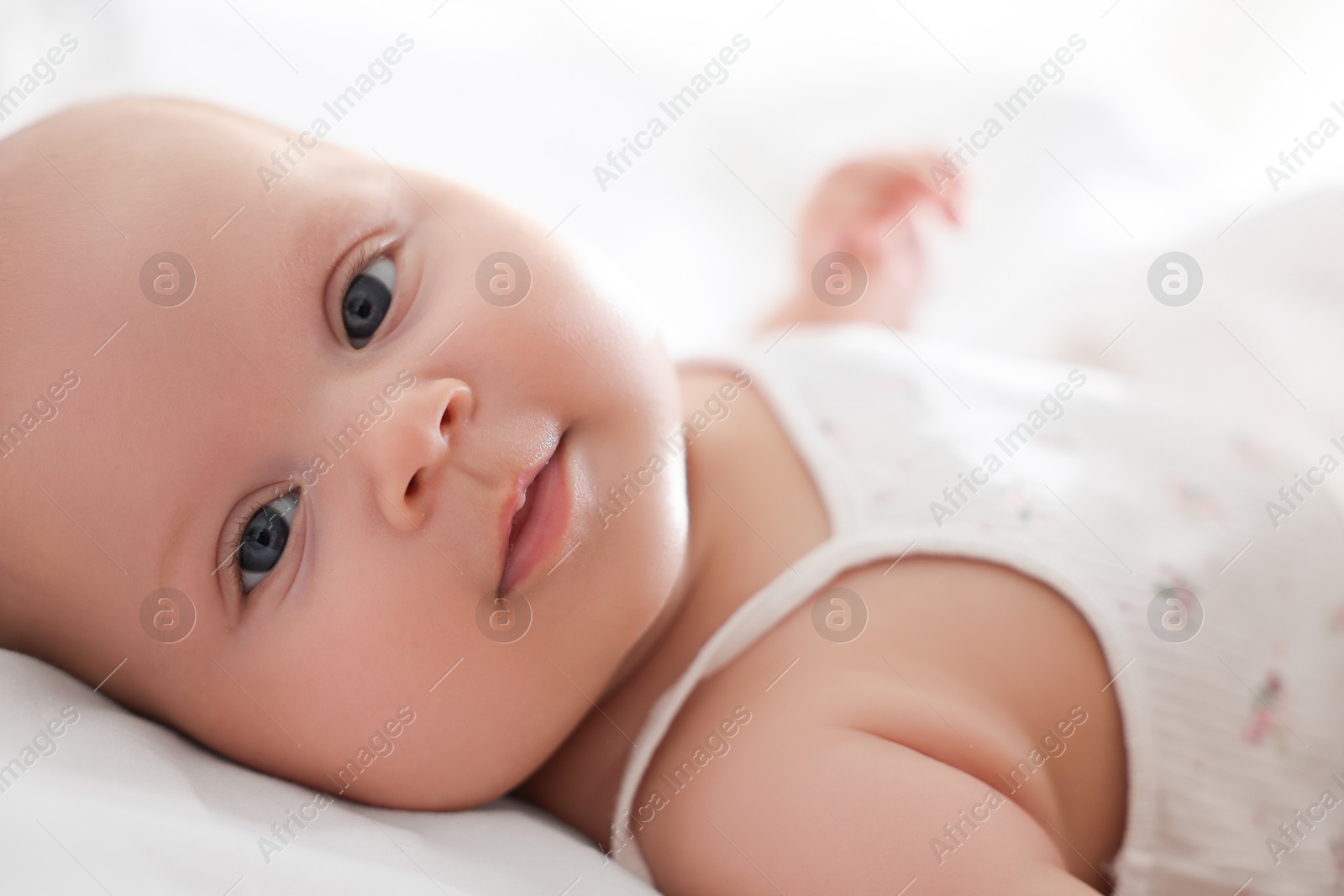 Photo of Cute little baby lying on bed at home