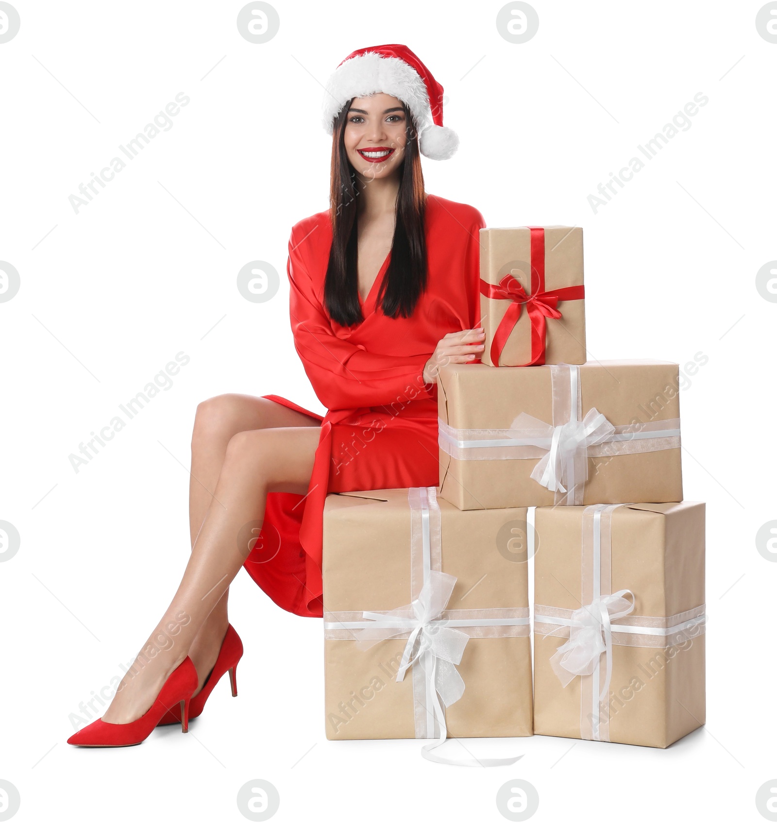 Photo of Woman in red dress and Santa hat with Christmas gifts on white background