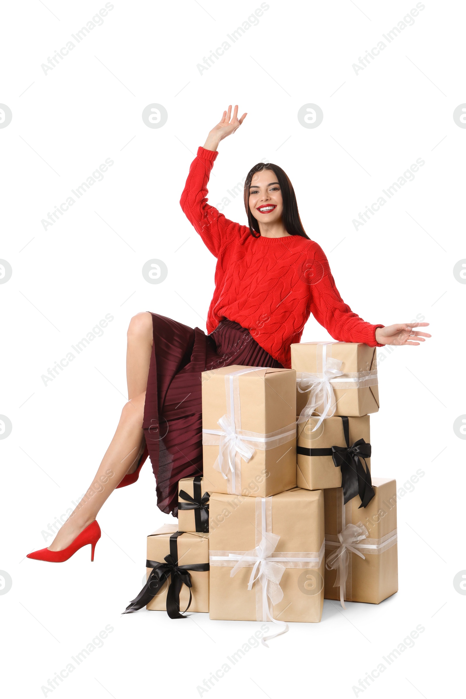 Photo of Woman in red sweater and burgundy skirt with Christmas gifts on white background