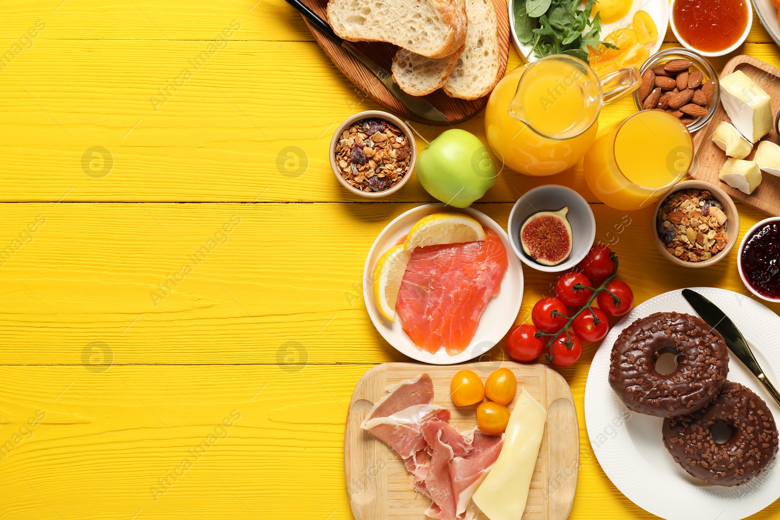 Photo of Different tasty food served for brunch on yellow wooden table, flat lay. Space for text