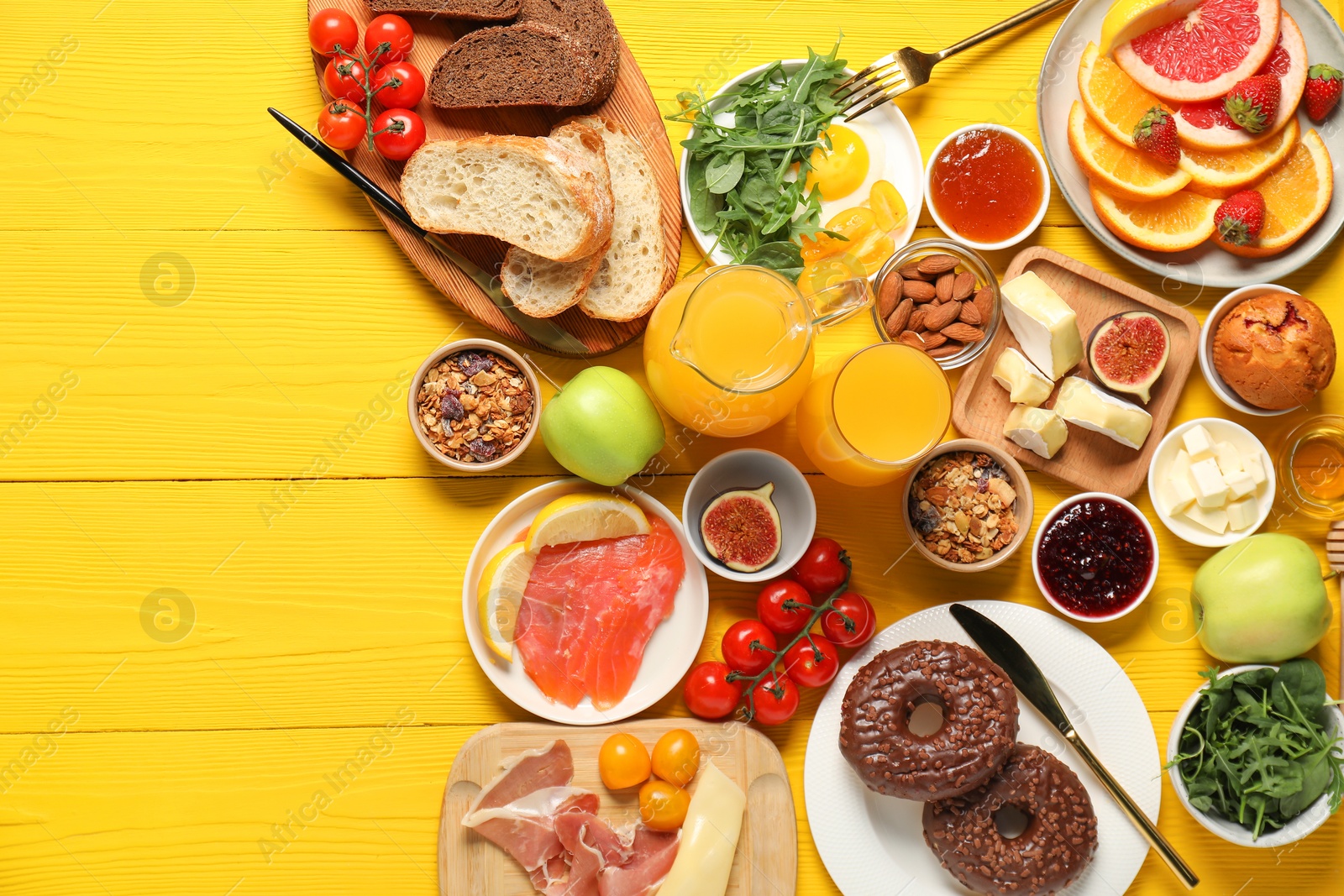 Photo of Different tasty food served for brunch on yellow wooden table, flat lay. Space for text