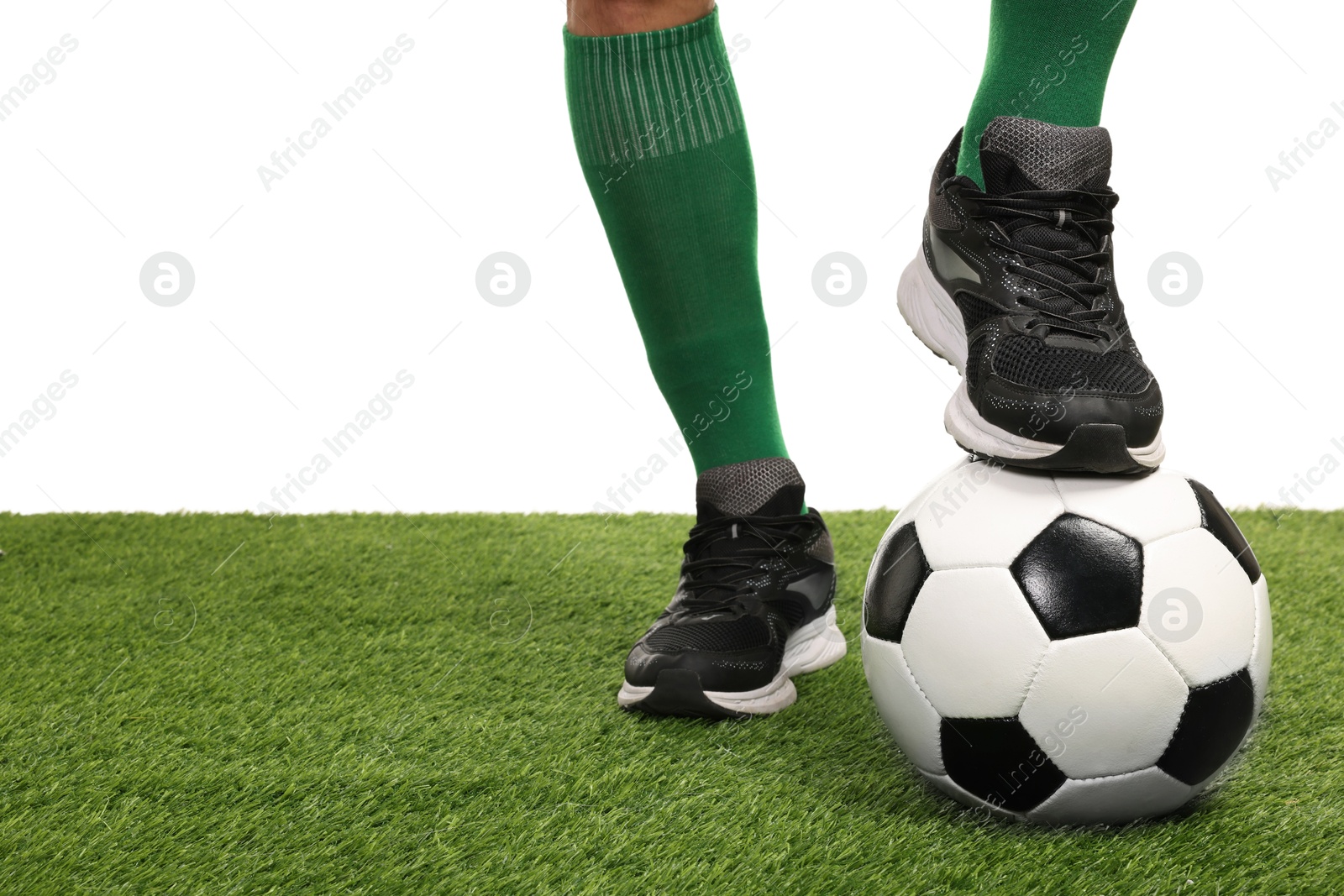 Photo of Football player with soccer ball on artificial grass against white background, closeup