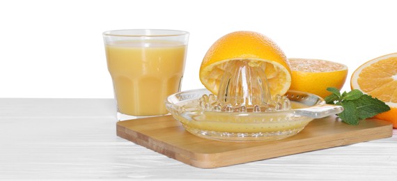 Photo of Glass juicer and fresh oranges on wooden table against white background