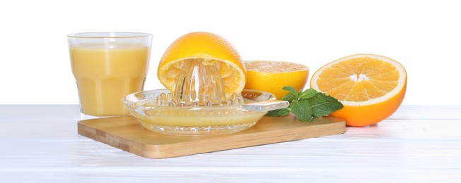 Photo of Glass juicer and fresh oranges on wooden table against white background