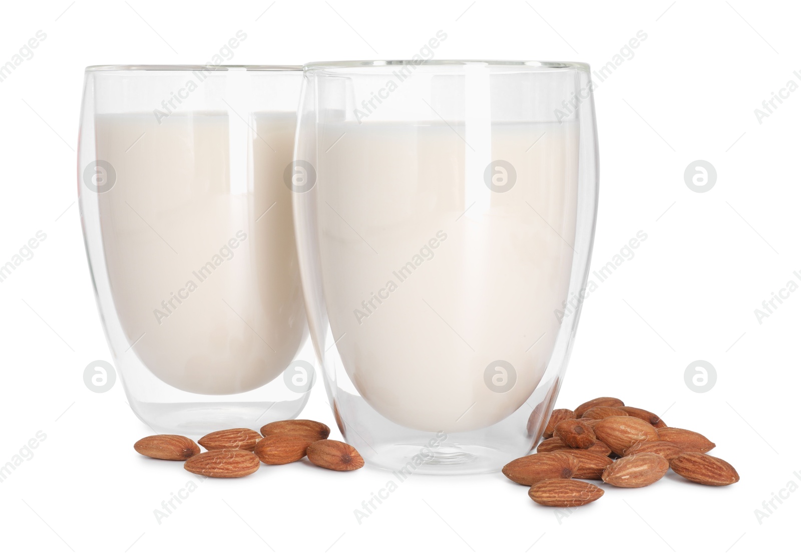 Photo of Glasses of almond milk and nuts isolated on white