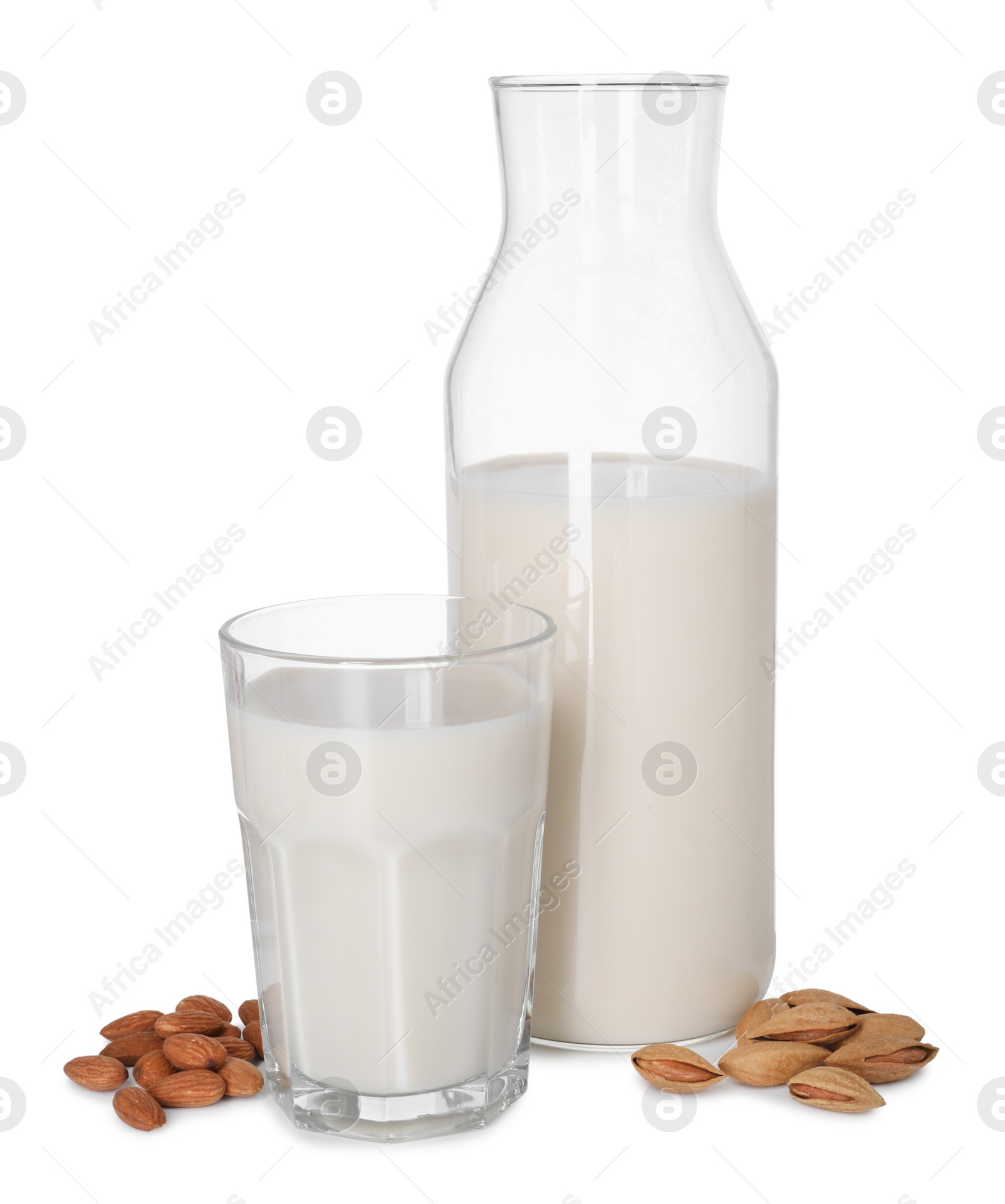 Photo of Glass and bottle of almond milk and nuts isolated on white