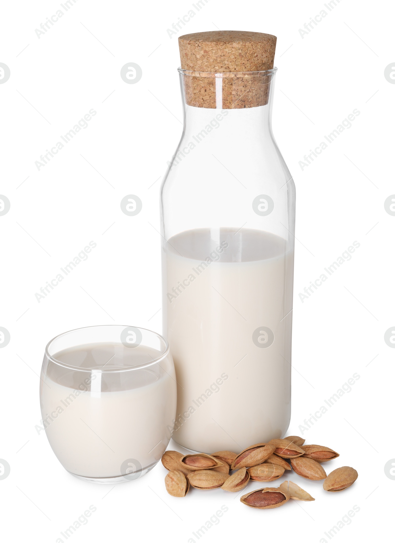 Photo of Glass and bottle of almond milk and nuts isolated on white