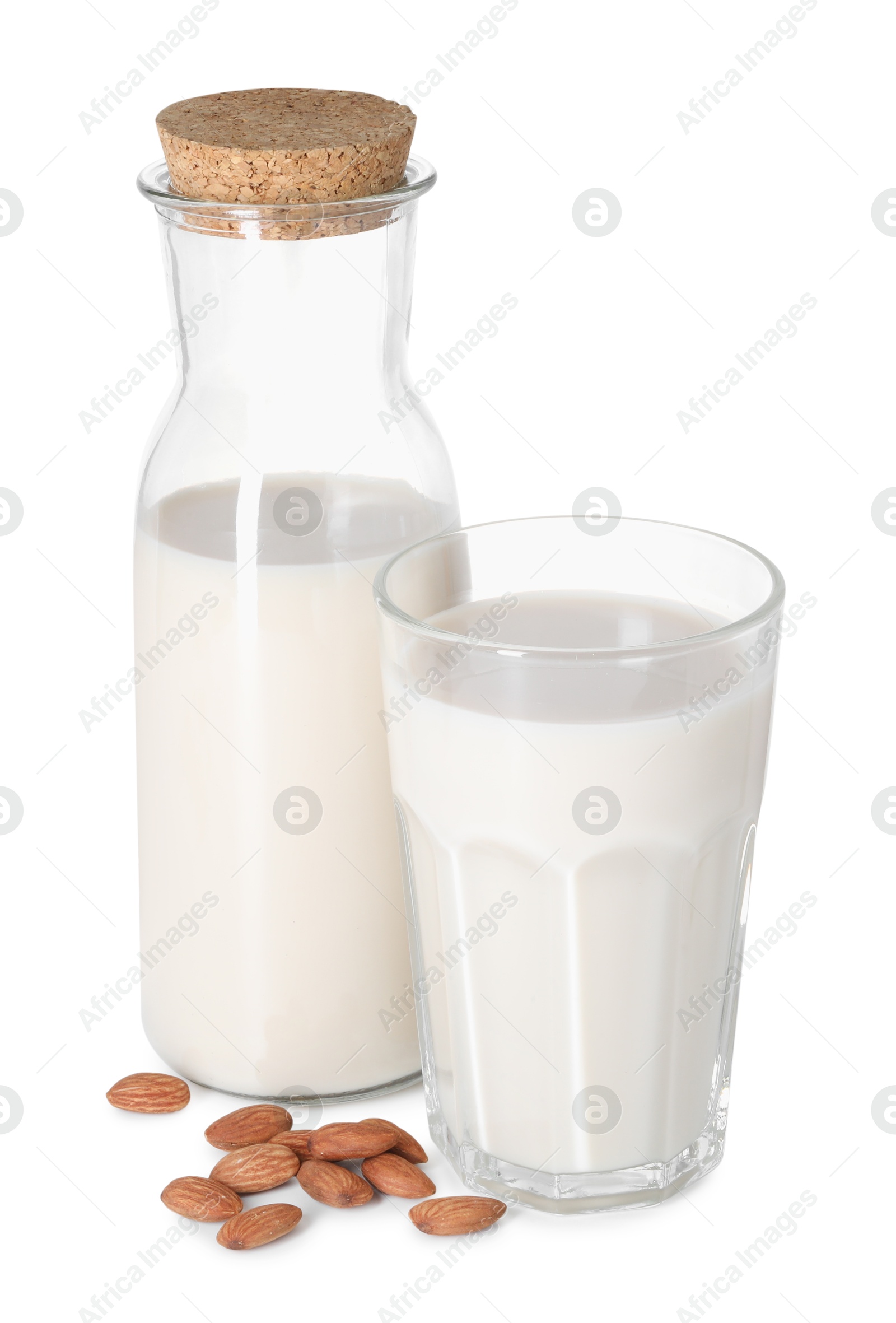 Photo of Glass and bottle of almond milk and nuts isolated on white