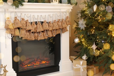 Advent calendar with gifts and decor hanging on fireplace Christmas near tree indoors