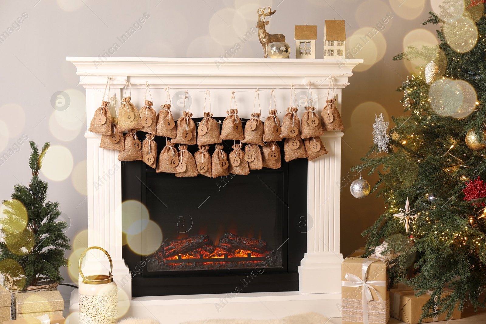 Photo of Advent calendar with gifts and decor hanging on fireplace Christmas near tree indoors