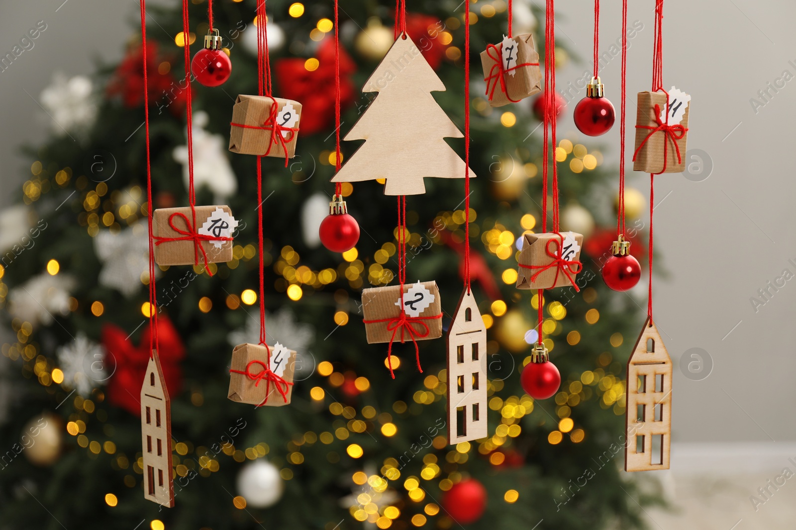 Photo of Handmade advent calendar with decor hanging near Christmas tree indoors