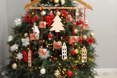 Photo of Handmade advent calendar with decor hanging near Christmas tree indoors