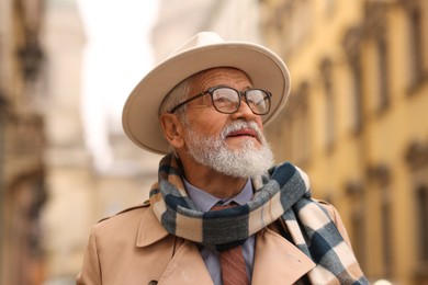 Photo of Portrait of elegant senior man in hat outdoors