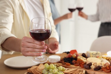 Photo of People with glasses of red wine indoors, selective focus