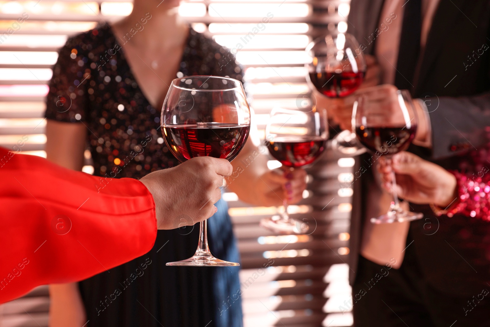 Photo of People clinking glasses of red wine at party, selective focus