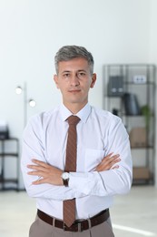 Photo of Portrait of businessman with crossed arms in office