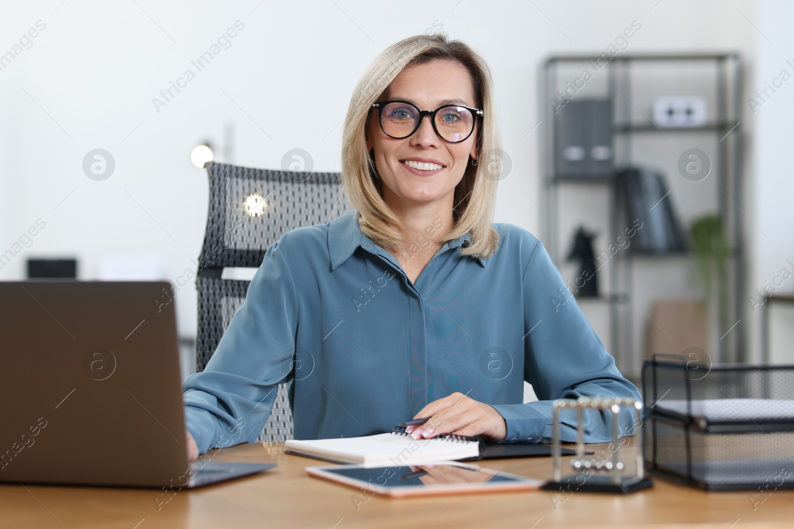 Photo of Businesswoman working on laptop at table in office