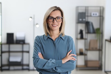 Photo of Portrait of happy businesswoman with crossed arms in office