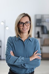 Photo of Portrait of happy businesswoman with crossed arms in office